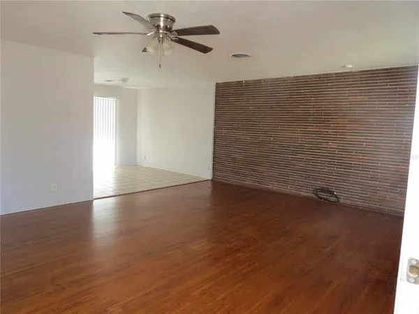 a view of an empty room with wooden floor