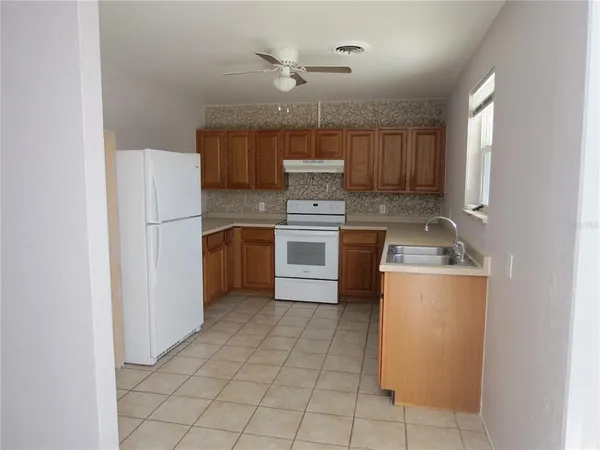 a kitchen with a stove a refrigerator and a sink