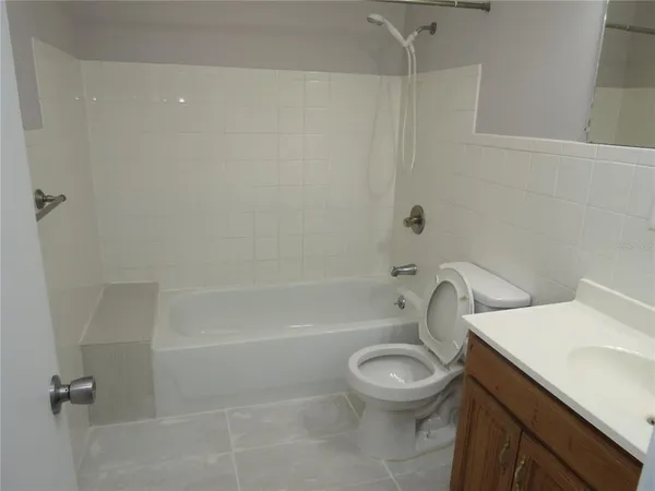 a white toilet sitting next to a bath tub