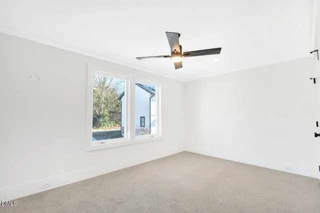 an empty room with a window and a fan