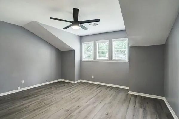 a view of room with window ceiling fan and hardwood floor