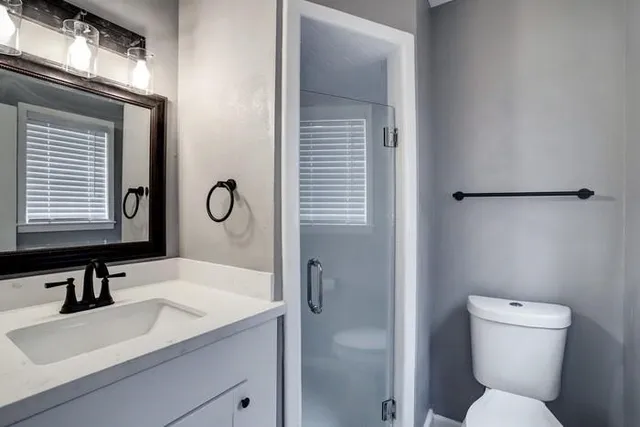 a bathroom with a sink toilet and shower