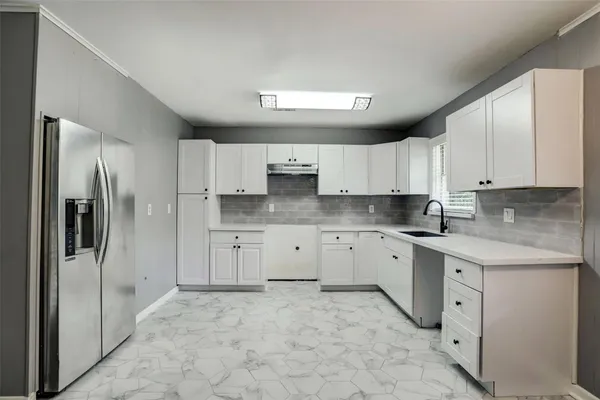 a large kitchen with cabinets stainless steel appliances and a counter space