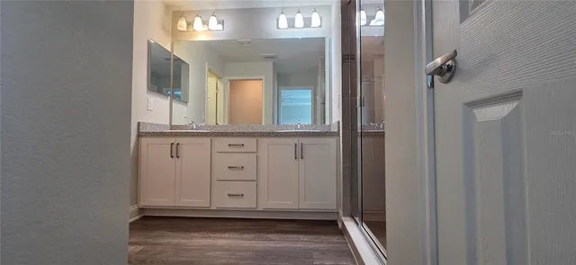 a view of a hallway with entryway wooden floor and cabinet