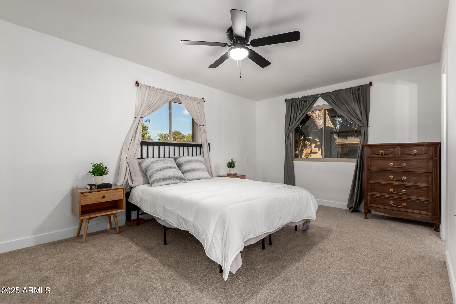 628 Leisure World Mesa, AZ 85206 - Photo 14 of 51 a spacious bedroom with a bed a dresser and a chandelier