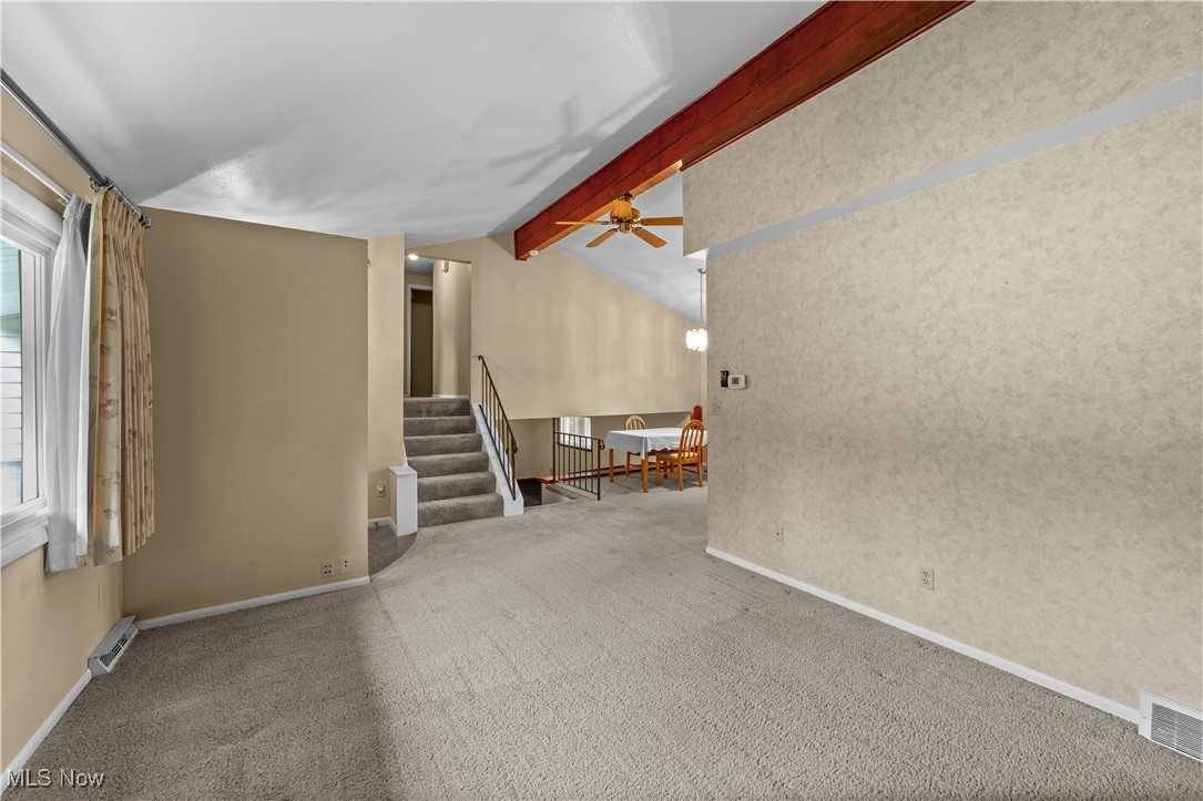 648 Rehwinkle Road Northfield, OH 44067 - Photo 6 of 38 Unfurnished room featuring carpet, stairs, and ceiling fan