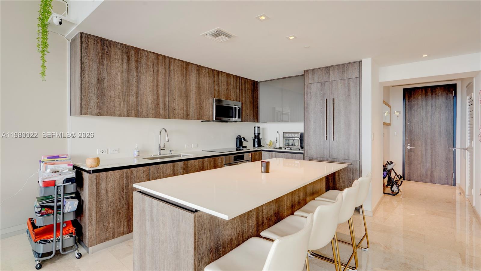 88 Southwest 7th Street, Unit 2706 Miami, FL 33130 - Photo 16 of 58 a kitchen with a sink a refrigerator and cabinets