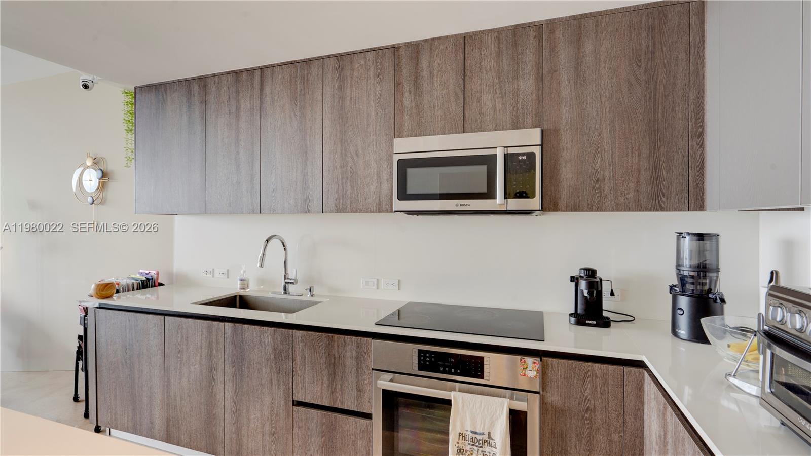 88 Southwest 7th Street, Unit 2706 Miami, FL 33130 - Photo 17 of 58 a kitchen with stainless steel appliances a stove a microwave sink and cabinets