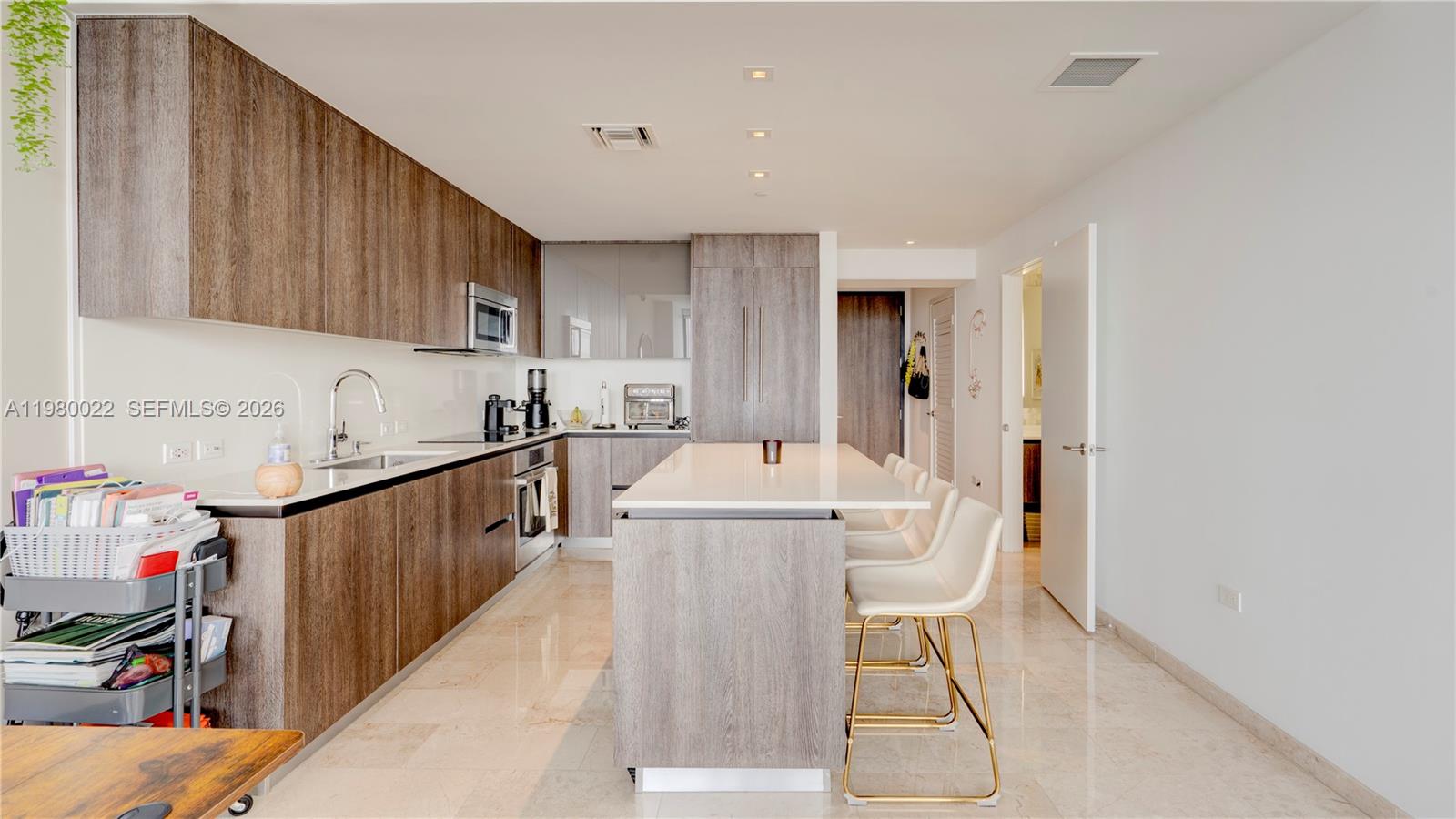 88 Southwest 7th Street, Unit 2706 Miami, FL 33130 - Photo 19 of 58 a kitchen with a dining table chairs and a wooden floor