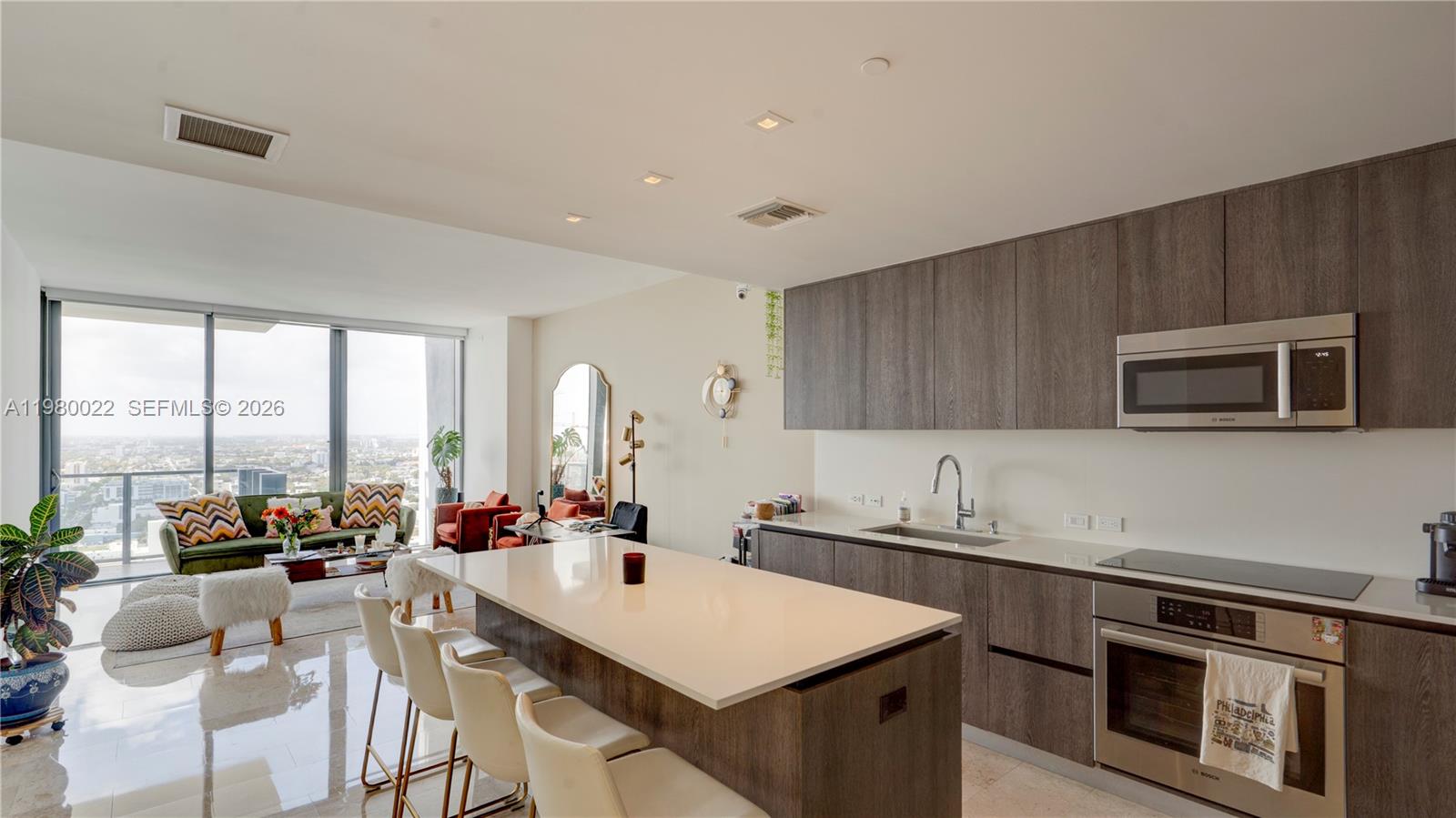 88 Southwest 7th Street, Unit 2706 Miami, FL 33130 - Photo 2 of 58 a kitchen with stainless steel appliances a stove a sink a microwave a dining table and chairs