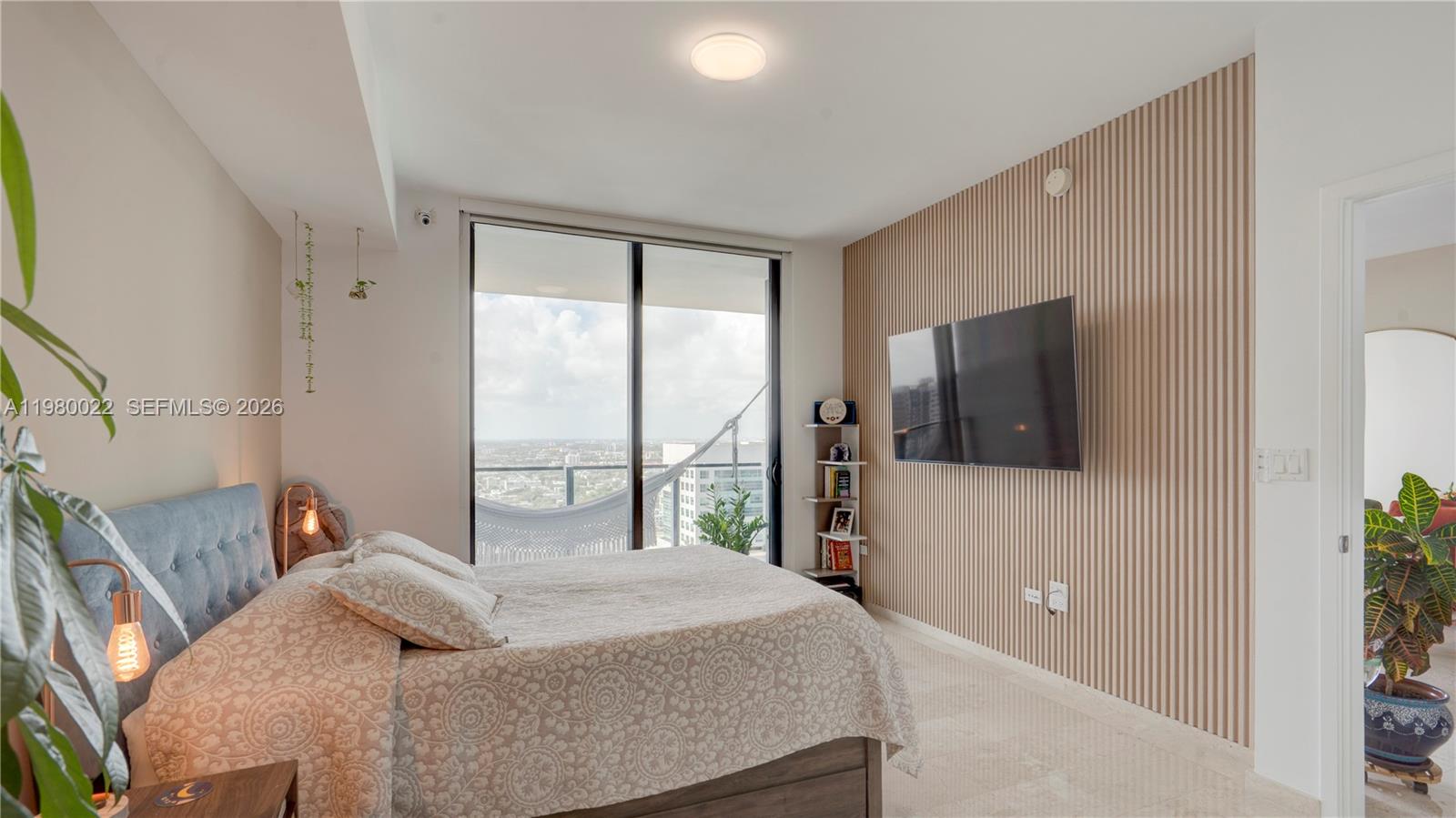 88 Southwest 7th Street, Unit 2706 Miami, FL 33130 - Photo 25 of 58 a bedroom with a large bed and a flat tv screen on dresser