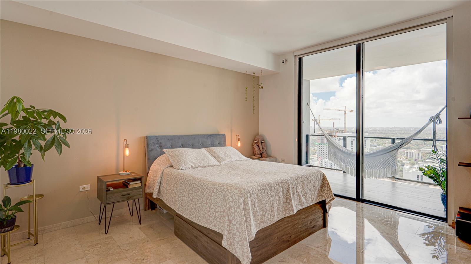 88 Southwest 7th Street, Unit 2706 Miami, FL 33130 - Photo 26 of 58 a bedroom with a large bed and a potted plant