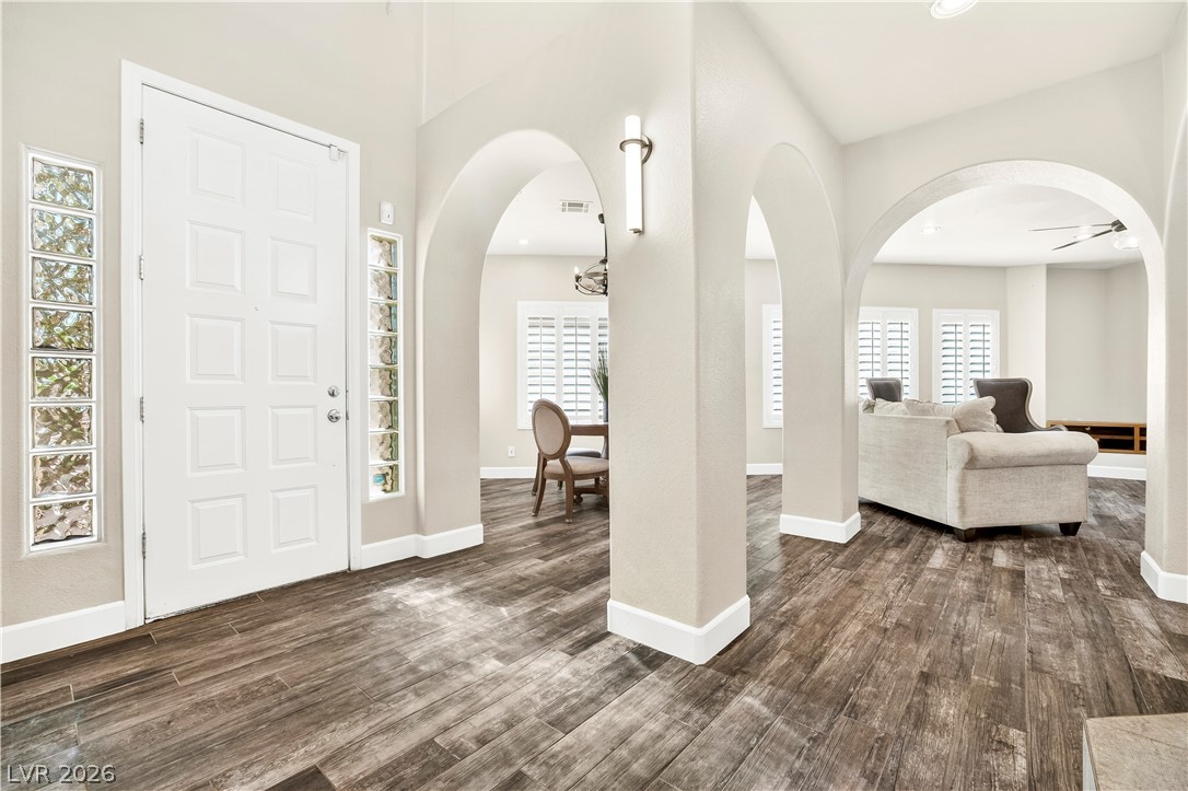 1135 Calico Ridge Drive Henderson, NV 89011 - Photo 9 of 86 Step into a luminous entryway featuring an elegant archway design and durable wood-look flooring.