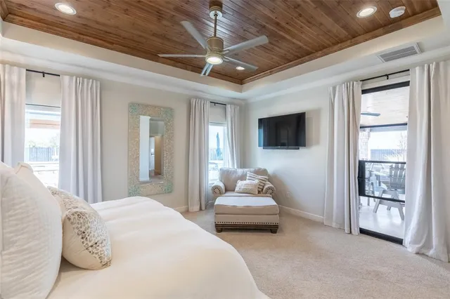 a spacious bedroom with a bed and a flat screen tv