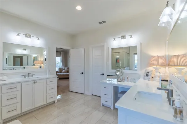a large bathroom with a double vanity sink and mirror with shower