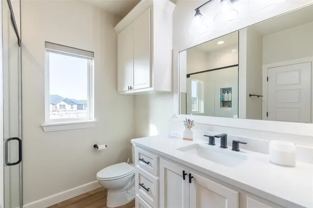 a bathroom with a granite countertop sink toilet and shower