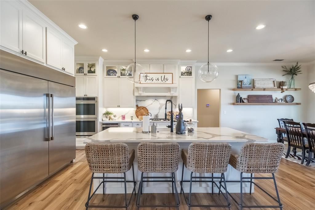 169 Pne Spgs Cove Tuscola, TX 79562 - Photo 8 of 40 a kitchen with stainless steel appliances kitchen island granite countertop a kitchen island a table and chairs