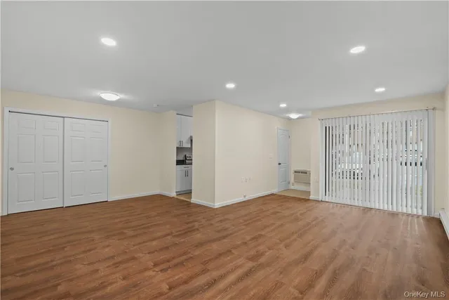 a view of an empty room with wooden floor