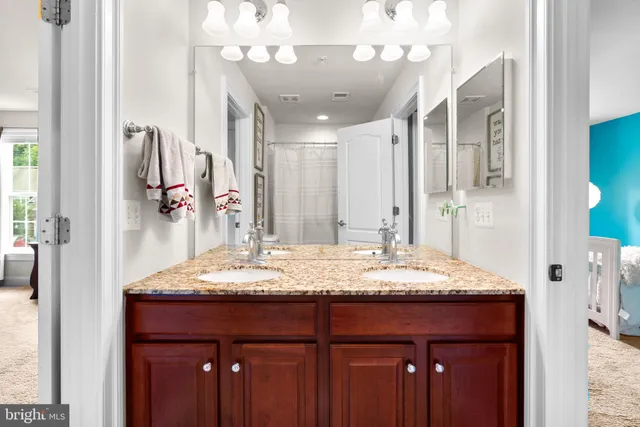 a bathroom with a granite countertop sink and a mirror