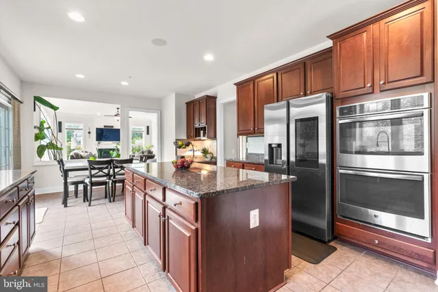 a kitchen with stainless steel appliances granite countertop a stove refrigerator and a sink