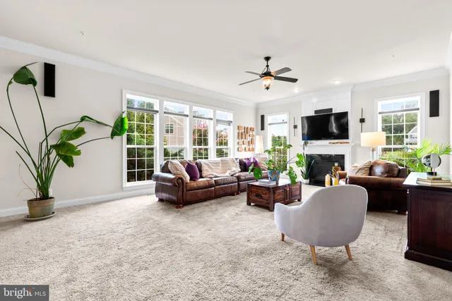 a living room with furniture fireplace and a large window