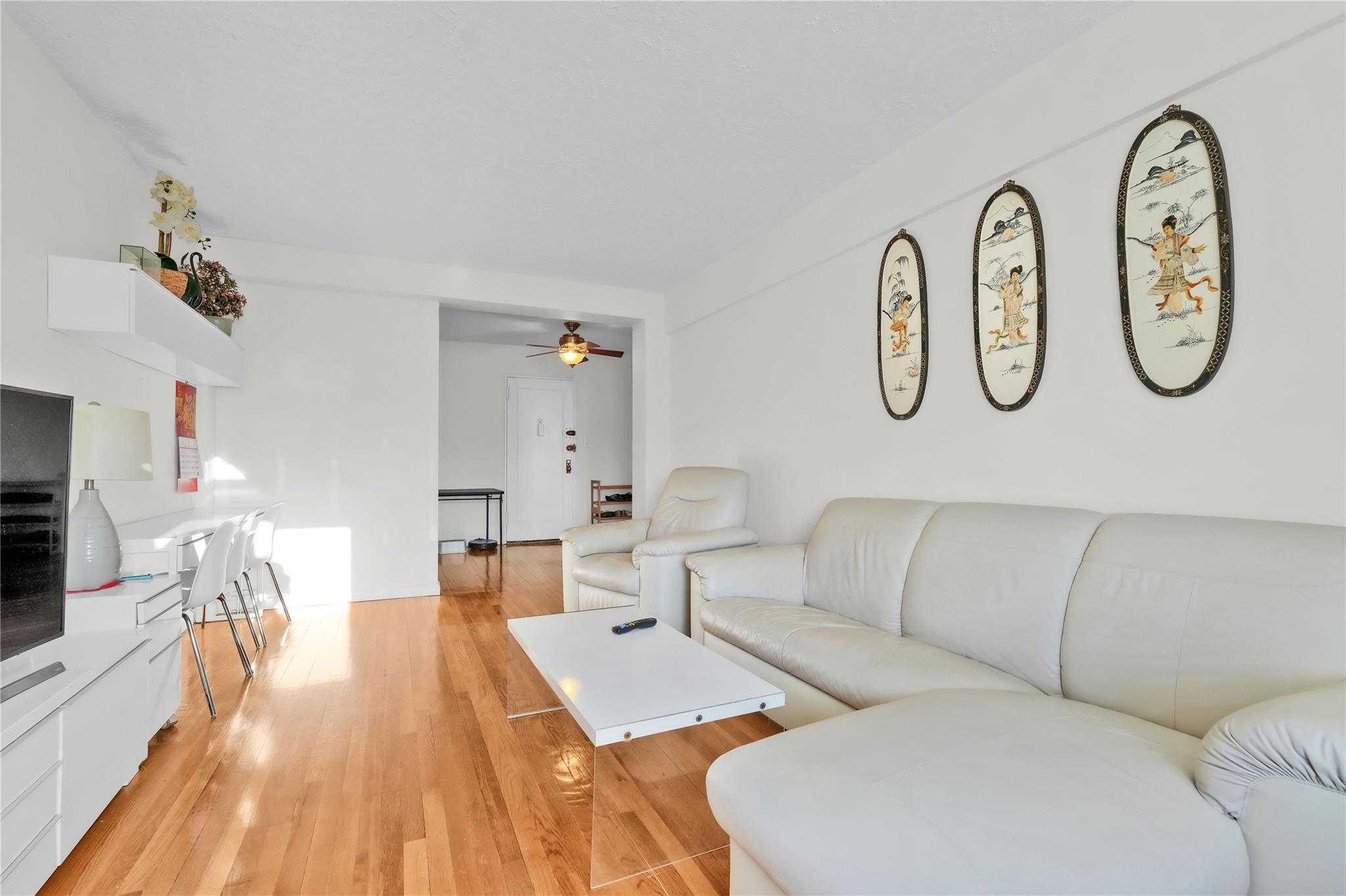 139-09 28th Road, Unit 6F Queens, NY 11354 - Photo 2 of 14 Living area with ceiling fan and light wood-style floors