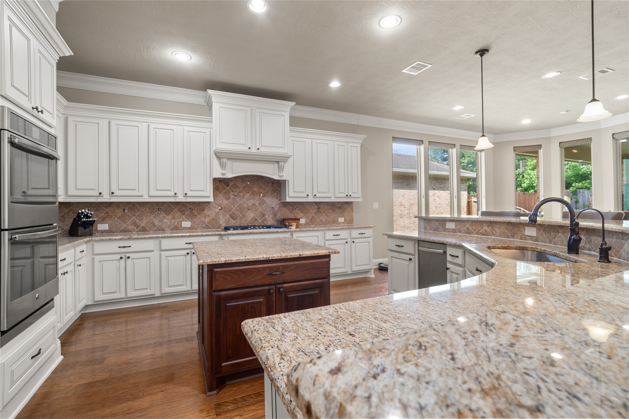 19813 Cullen Ridge Drive Porter, TX 77365 - Photo 11 of 44 Discover this dreamy kitchen, boasting elegant white cabinetry, granite countertops, and abundant natural light for a truly inviting space.