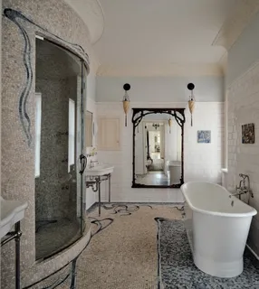 a bathroom with a tub a mirror and a shower