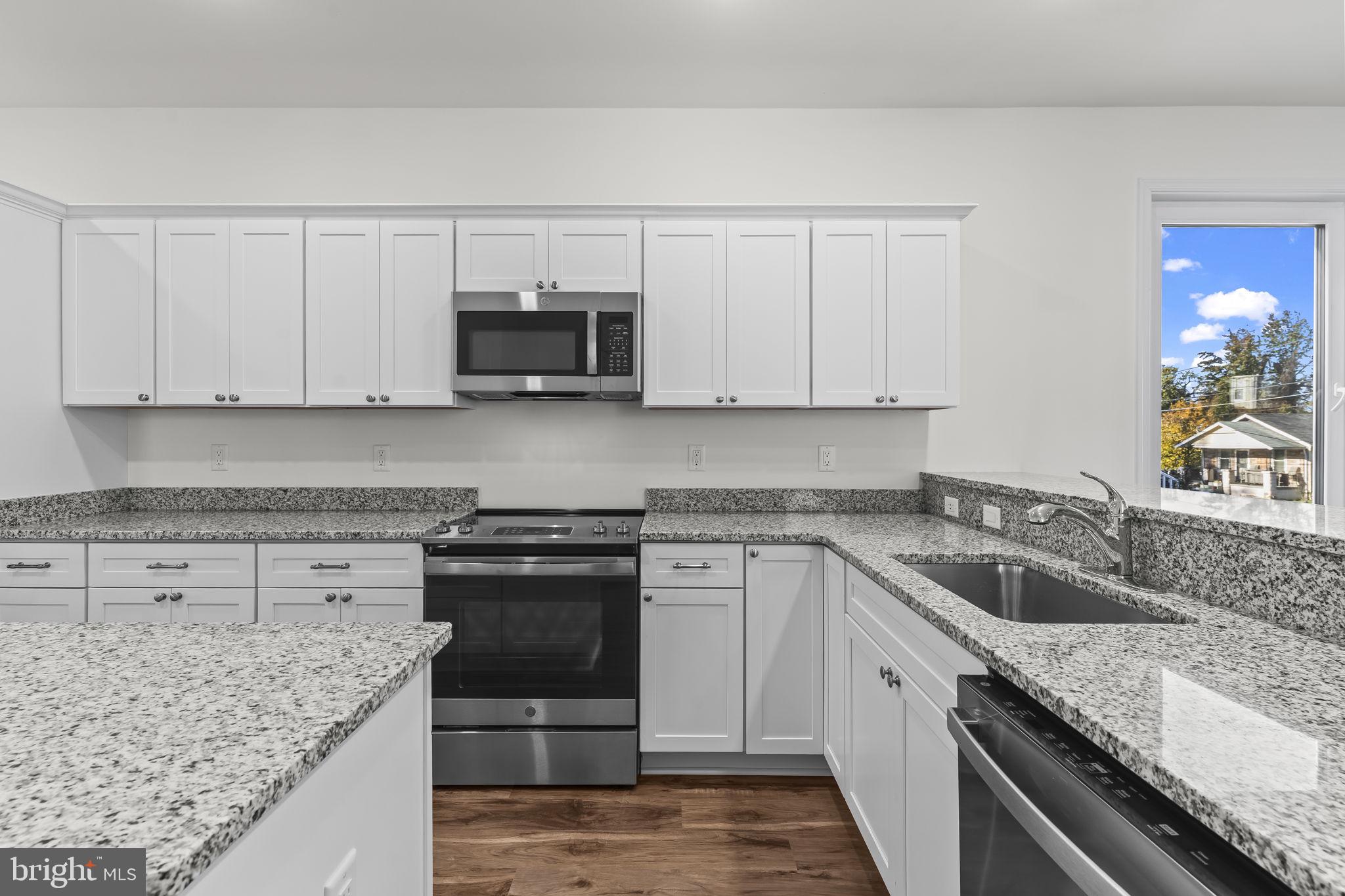 721 60th Place Capitol Heights, MD 20743 - Photo 11 of 33 a kitchen with granite countertop a sink a stove and microwave