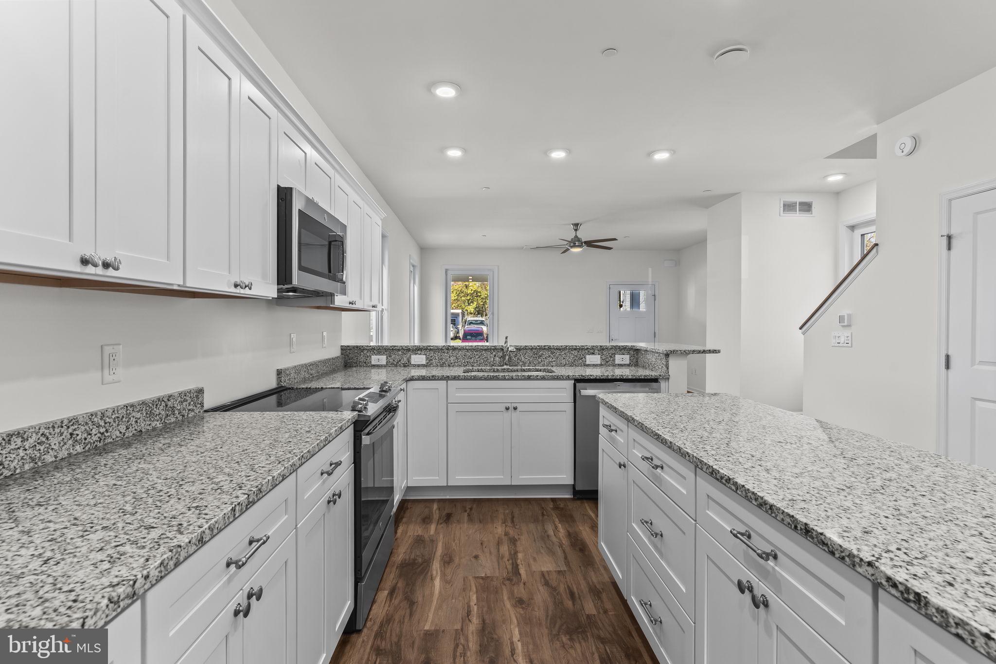 721 60th Place Capitol Heights, MD 20743 - Photo 13 of 33 a kitchen with granite countertop sink stainless steel appliances and white cabinets