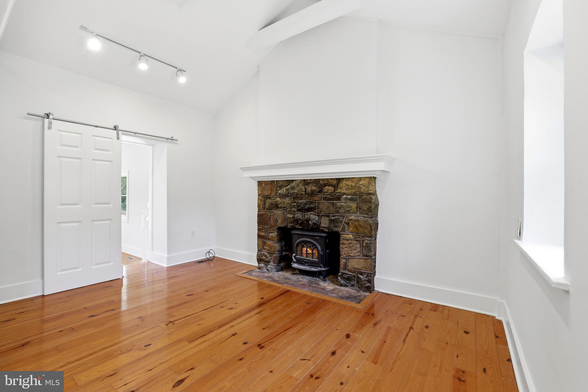 17781 Roxbury Hall Road Leesburg, VA 20175 - Photo 66 of 107 an empty room with wooden floor fireplace and windows