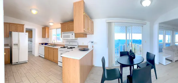 a kitchen that has a lot of white cabinets and stainless steel appliances