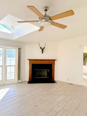 a view of an empty room with a fireplace and a window