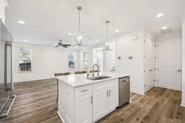 a hall with kitchen island white cabinets and sink