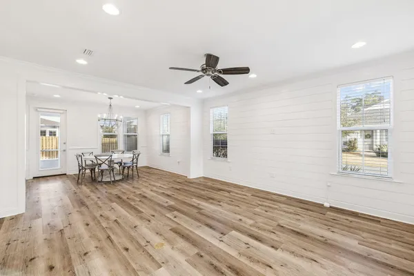 a view of an empty room with window and wooden floor