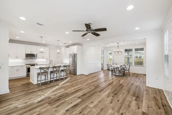 a view of a kitchen with dining table chairs and wooden floor