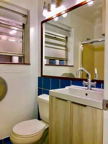 a bathroom with a sink a toilet and mirror