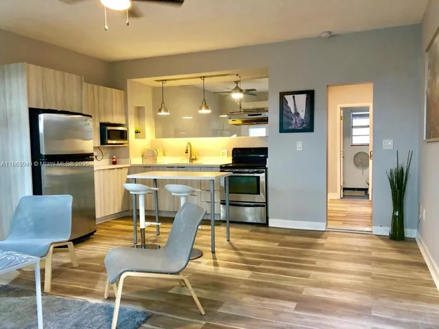a kitchen with a table chairs refrigerator and microwave