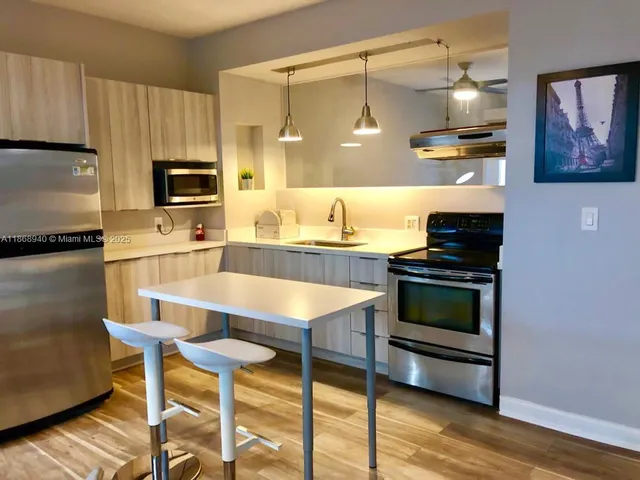 a kitchen with kitchen island granite countertop wooden cabinets and stainless steel appliances
