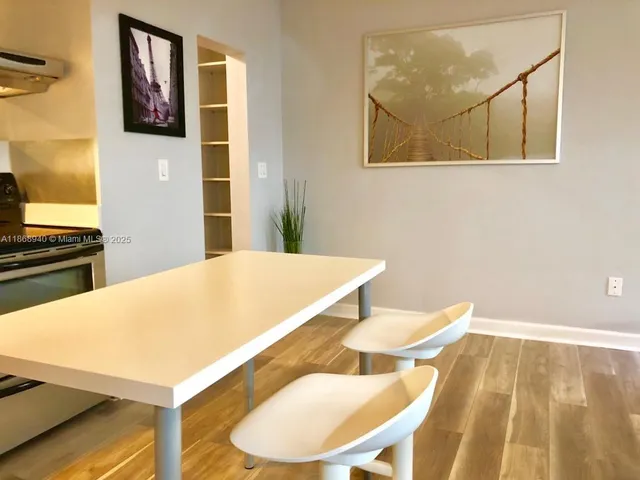 a view of a kitchen with furniture and wooden floor