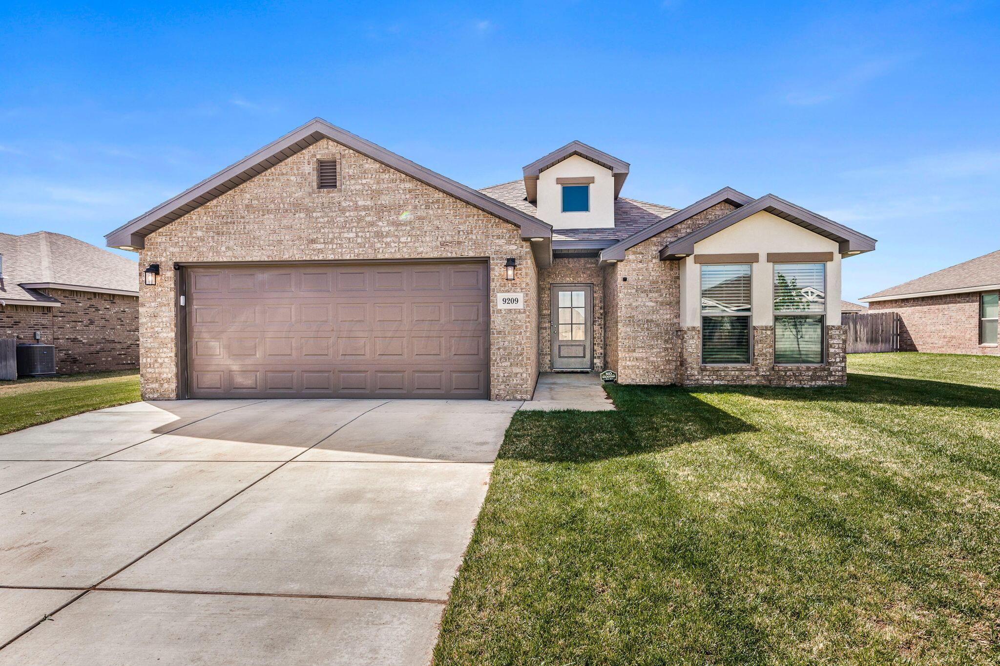 9209 Lexford Drive Amarillo, TX 79119 - Photo 1 of 23 a front view of a house with a yard and garage