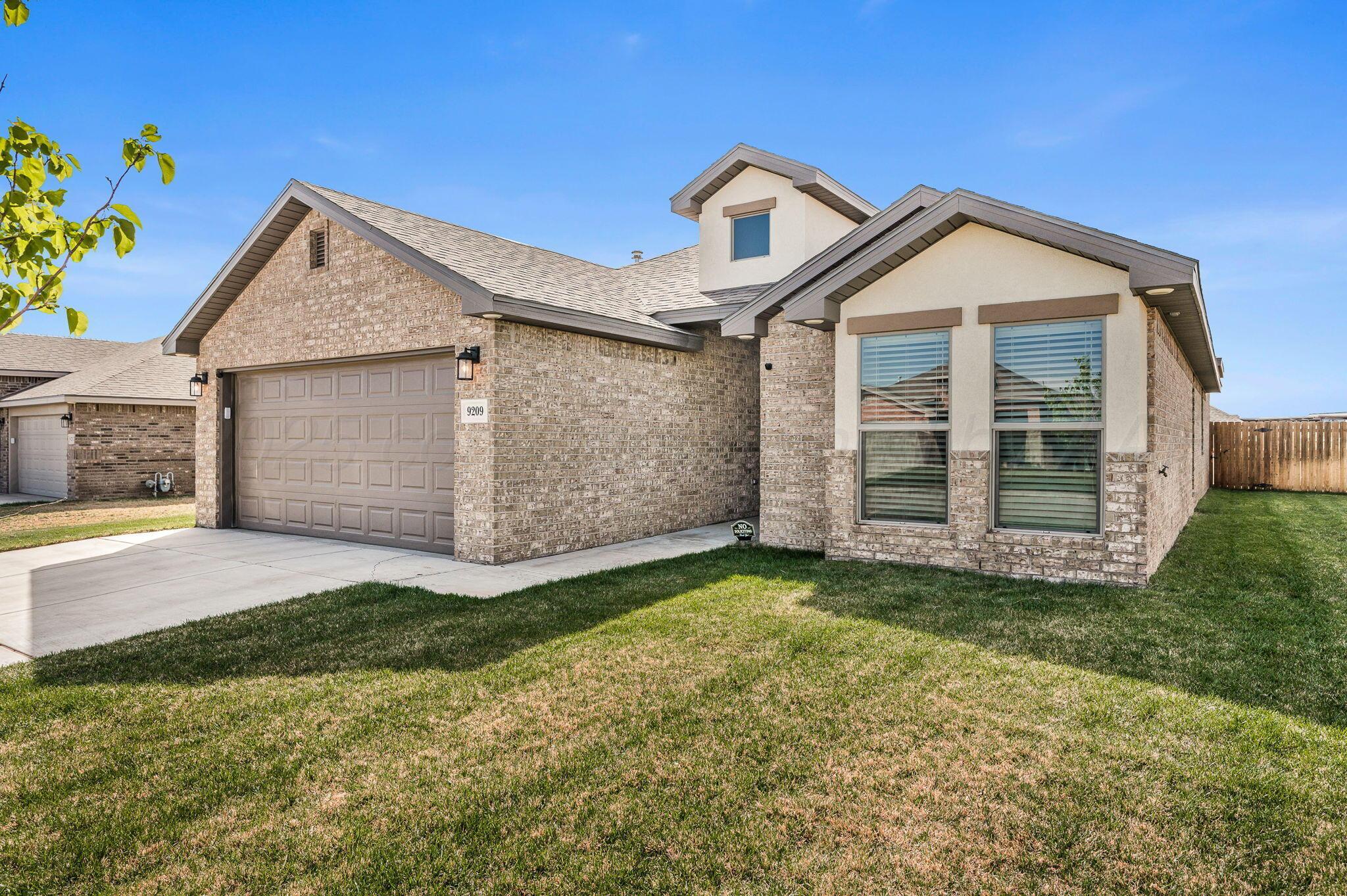 9209 Lexford Drive Amarillo, TX 79119 - Photo 2 of 23 a front view of a house with a yard