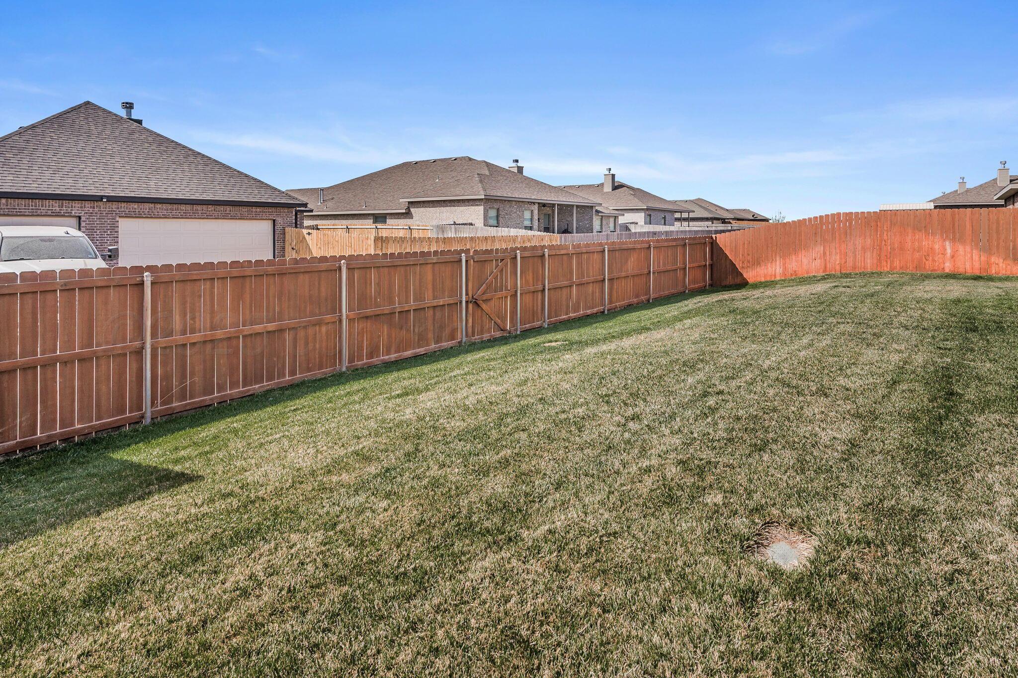 9209 Lexford Drive Amarillo, TX 79119 - Photo 22 of 23 a view of a backyard with a garden and wooden fence
