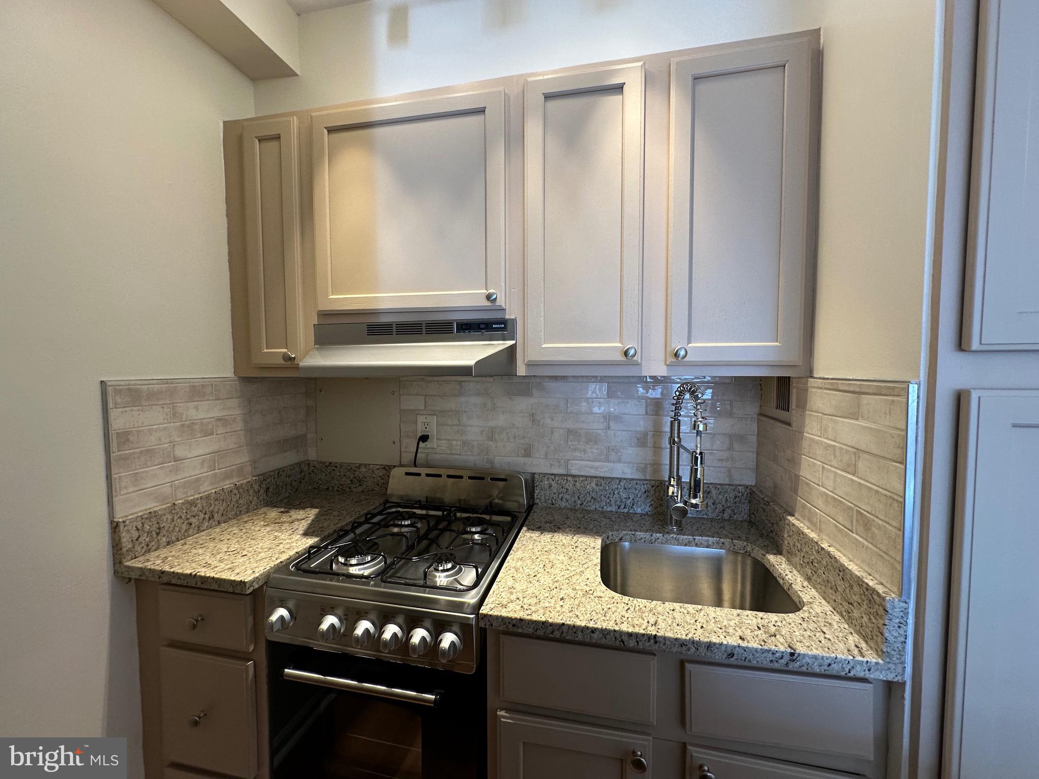 2101 Chestnut Street, Unit 811 Philadelphia, PA 19103 - Photo 8 of 17 a kitchen with a sink a stove and cabinets