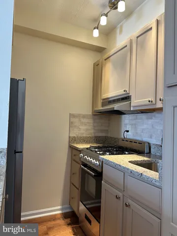 a kitchen with stainless steel appliances granite countertop a stove a microwave and a refrigerator