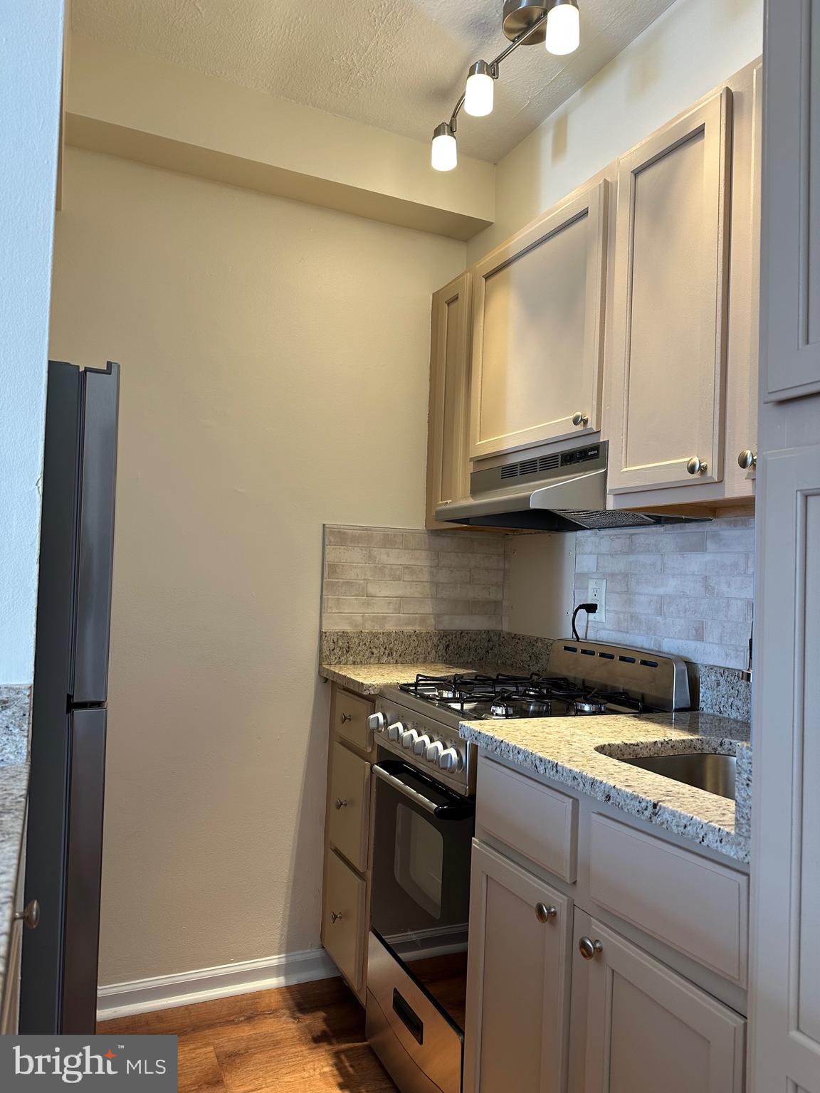 2101 Chestnut Street, Unit 811 Philadelphia, PA 19103 - Photo 10 of 17 a kitchen with stainless steel appliances granite countertop a stove a microwave and a refrigerator