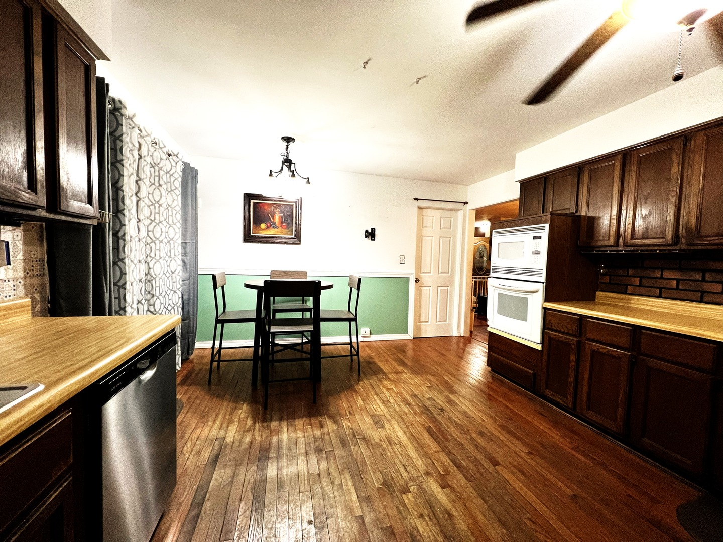 1930 23rd Street Zion, IL 60099 - Photo 6 of 20 a kitchen with stainless steel appliances wooden floor and chairs