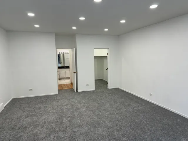 an empty room with closet and white doors