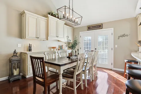a dining room with furniture a chandelier and wooden floor