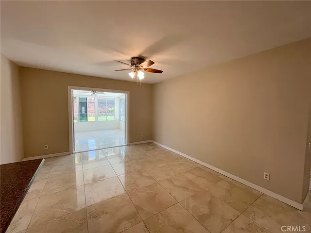 a view of an empty room with a chandelier fan
